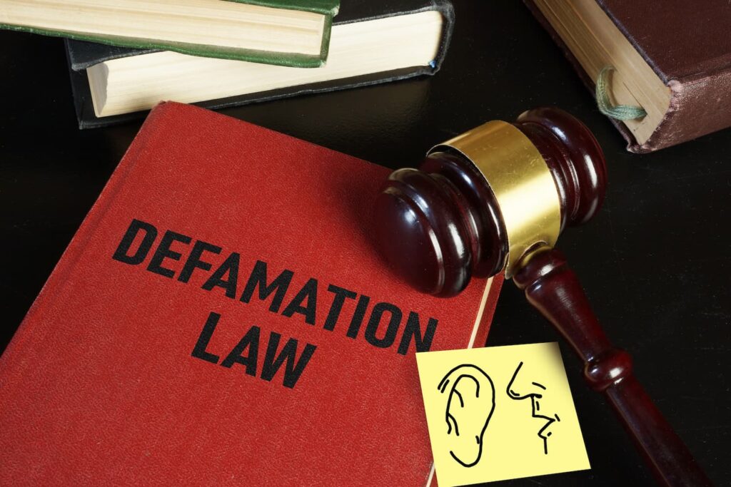 Defamation law book with judge gavel symbolizing business defamation lawsuits and legal strategies to protect company reputation