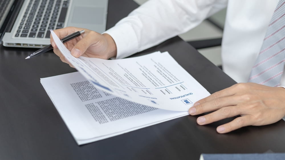 Business owner reviewing employment contracts during merger due diligence process