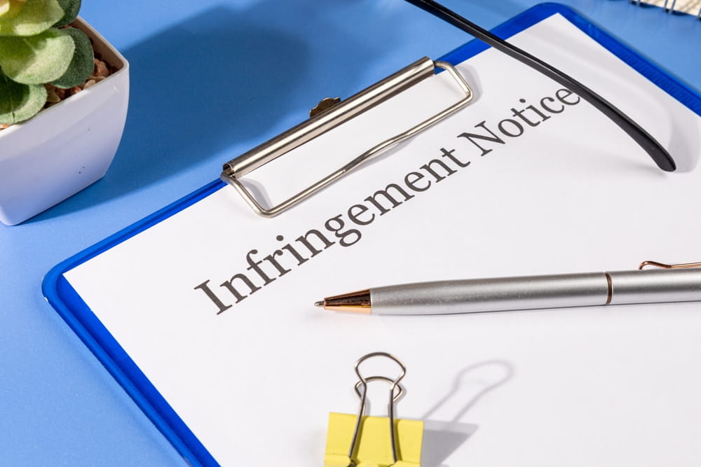 Trademark infringement notice on clipboard representing cease and desist letter to stop unauthorized brand use.