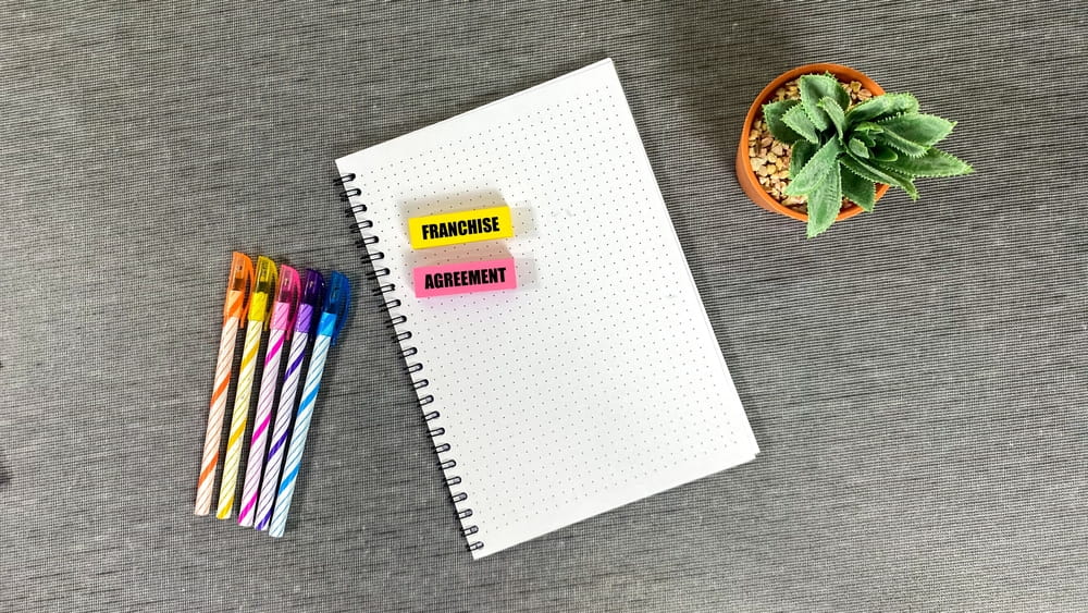 Notebook labeled franchise agreement representing legal review for ending a franchise in Melbourne FL