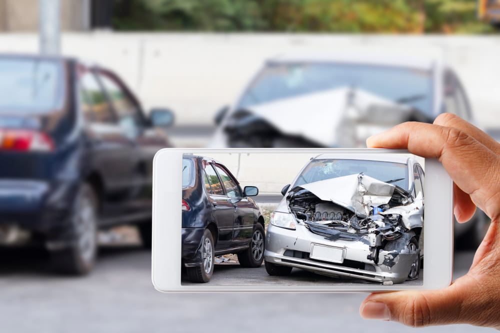 Driver photographing vehicle damage after a car accident in Melbourne Florida to document evidence for a claim