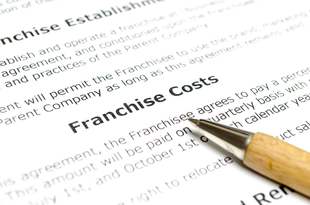 Close-up of a franchise contract discussing franchise costs and financial obligations for franchise owners in Florida.