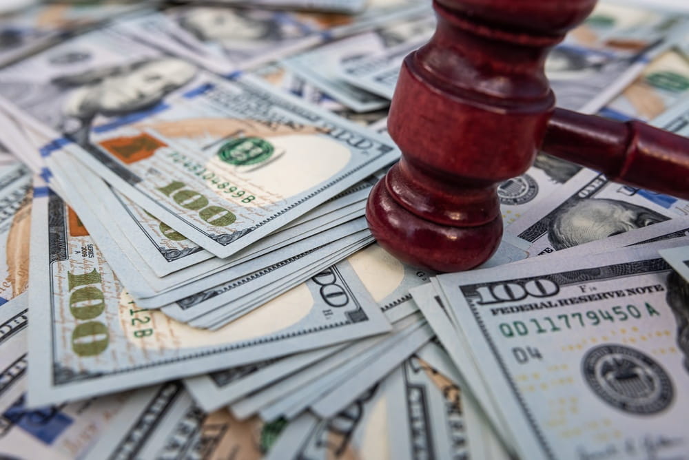 Judge&rsquo;s gavel resting on stacks of U.S. currency, symbolizing financial disputes, franchise litigation, and hidden business costs.