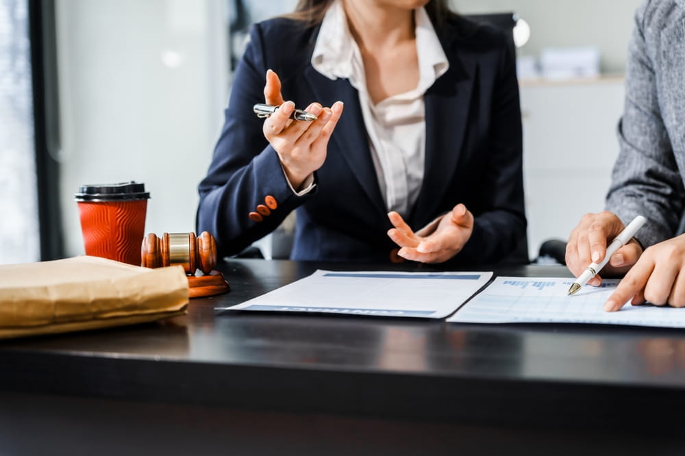 Attorney consulting with business professionals during a legal meeting about franchise operations and dispute management.
